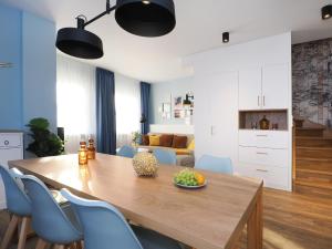 una cucina e una sala da pranzo con tavolo in legno e sedie blu di Seebrücke Heringsdorf - Appartement mit 2 Schlafzimmern und Terrasse S21 a Heringsdorf