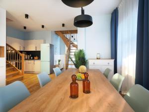 Il comprend une cuisine et une salle à manger avec une table et des chaises en bois. dans l'établissement Seebrücke Heringsdorf - Appartement mit 2 Schlafzimmern und Terrasse S21, à Heringsdorf