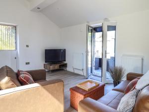 a living room with a couch and a tv at Tan Llech in Harlech