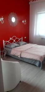 a bedroom with a bed with a red wall at Near Yerevan Serlinhouse in Oshakan