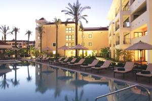 una piscina en un hotel con sillas y sombrillas en As Cascatas Golf Resort & Spa en Vilamoura