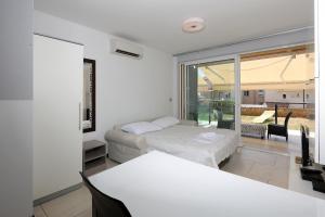 een witte kamer met een bed en een tafel bij Waterfront Apartments with Pool in Novalja