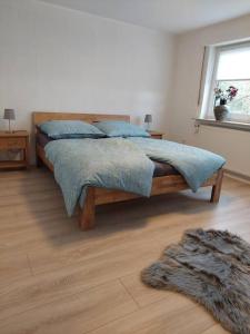 1 dormitorio con cama con sábanas azules y alfombra en Ferienhaus Weitblick, en Olsberg