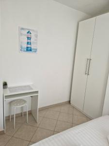 a bedroom with a desk and a white cabinet at Apartment Relax - 80 m from the beach in Sveti Filip i Jakov
