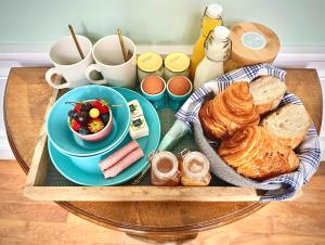 a tray with a plate of bread and a bowl of fruit at The Stay Well in Boulogne-sur-Mer