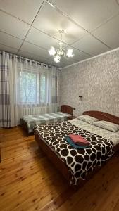 a bedroom with two beds and a chandelier at Lotos Guest House in Bishkek