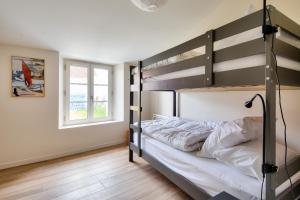 a bedroom with a bunk bed with white sheets at Detente dans une jolie maison a Noimoutier in Noirmoutier-en-l'lle