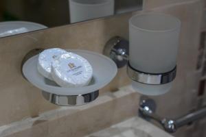 eine weiße Platte auf der Badezimmertheke mit einer Kerze in der Unterkunft Apart Hotel Los alazanes in Capilla del Monte