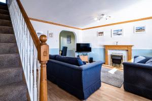 a living room with two couches and a fireplace at Seaside Home with Sea Views in Balmedie