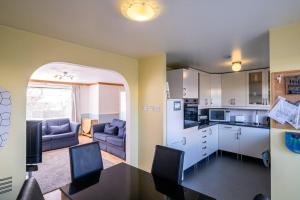 cocina y sala de estar con mesa y sillas en Seaside Home with Sea Views, en Balmedie