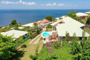 an aerial view of a house with the ocean in the background at Villa Frangipanier in Case-Pilote