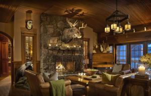a living room with a stone fireplace in a house at Mirror Lake Inn Resort and Spa in Lake Placid
