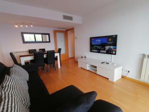 a living room with a couch and a table and a television at Apartment Airport Barcelona Premium in Viladecáns