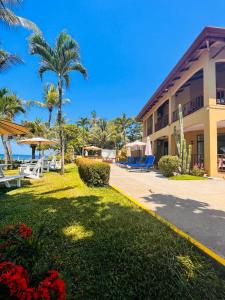 un complejo con palmeras y un edificio en The Backyard Beachfront Hotel, en Jacó