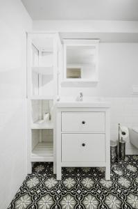 a white bathroom with a sink and a mirror at Central studio basement apartment in Bergen