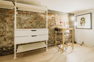 a bedroom with a white dresser and a brick wall at Central studio basement apartment in Bergen