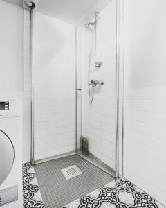 a shower with a glass door in a bathroom at Central studio basement apartment in Bergen