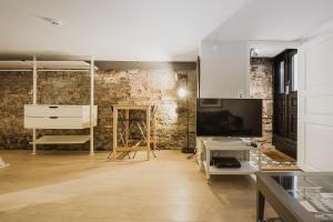a room with a brick wall and a tv and a desk at Central studio basement apartment in Bergen