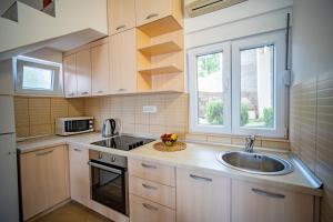 a small kitchen with a sink and a window at Apartments Novo Mulo in Tivat