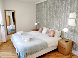 リスボンにあるCozy Avenida Guesthouseのベッドルーム(大きな白いベッド1台、鏡付)