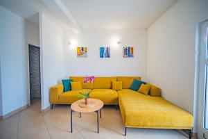 a living room with a yellow couch and a table at Apartments Novo Mulo in Tivat