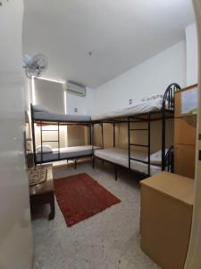 a room with three bunk beds and a table at Farah Hotel in Amman