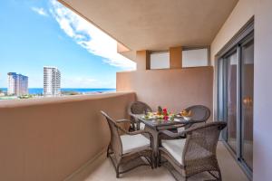 Gina s Sun Terrace في بلايا بارايسو: طاولة وكراسي على شرفة مطلة على المحيط