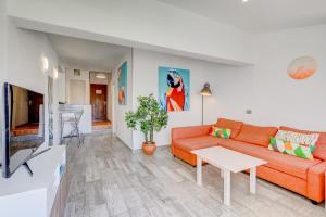 a living room with a orange couch and a table at Aguaviva FREE WIFI by Olax Rentals in Callao Salvaje