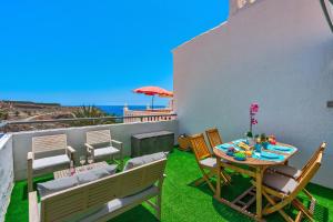 a patio with a table and chairs and the ocean at Aguaviva FREE WIFI by Olax Rentals in Callao Salvaje