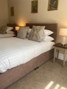 una camera da letto con letto, lenzuola e cuscini bianchi di Adams Townhouse a Dingle