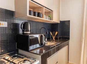 a small kitchen with a sink and a microwave at Luxe Studio and 1 bedroom Apartment in Naivasha