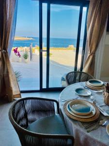 Kartika Charming House في لامبيدوسا: طاولة مع كراسي وإطلالة على الشاطئ