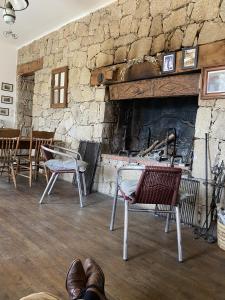 Habitación con sillas y chimenea de piedra. en Buvolaccia, 