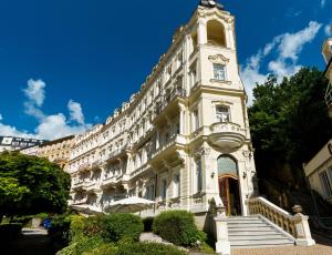a large white building with a clock tower at Spa Hotel Anglický Dvůr in Karlovy Vary