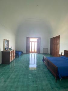 a bedroom with a blue bed and a green floor at Casa di don Francesco in Scala