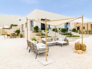 a patio with chairs and a canopy in front of a house at Kartika Charming House in Lampedusa