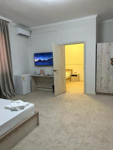 a room with two beds and a sliding door at Hotel Bereke in Atyraū