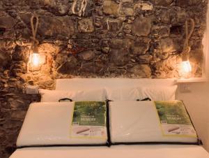Zwei Bücher liegen auf einem Bett vor einer Steinmauer. in der Unterkunft Gemma Maris in Sapri + 39 Fotos