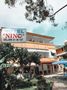 Una señal de hotel nino frente a un edificio en Hotel Nino, en Dhërmi