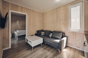 a living room with a couch and a window at Holiday Siesta Pensjonat, Domki in Rewal