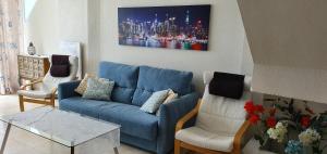 un soggiorno con divano blu e 2 sedie di Sea View Penthouse Duplex near Beach a Mijas Costa
