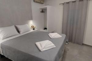 Un dormitorio con una cama con dos toallas encima. en v&n villa santorini, en Fira