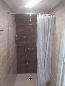 um chuveiro com uma cortina de chuveiro branca na casa de banho em K Farm House em Kalavárda
