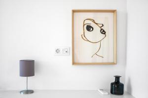 a painting of a person on a wall next to a lamp at Brand New River View Apartment Belém - 1 bedroom, A/C in Lisbon