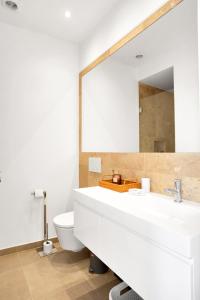uma casa de banho com um lavatório branco e um espelho. em Brand New River View Apartment Belém - 1 bedroom, A/C em Lisboa