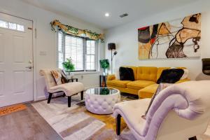 a living room with a yellow couch and chairs at Modern Newark Vacation Rental Near Downtown! in Newark