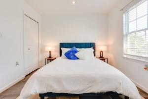 a bedroom with a large white bed with blue pillows at Modern Newark Vacation Rental Near Downtown! in Newark