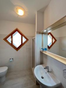 リニャーノ・サッビアドーロにあるResidenza Quadrifoglioのバスルーム(洗面台、鏡、トイレ付)