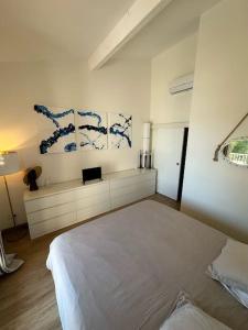 1 dormitorio con cama blanca y pinturas azules en la pared en L'Atelier Marin sur le Port des Marines, en Cogolin