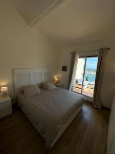 1 dormitorio con cama grande y ventana grande en L'Atelier Marin sur le Port des Marines, en Cogolin
